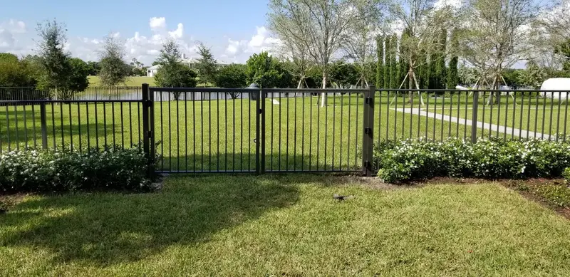Black aluminum fence with double gate in residential yard