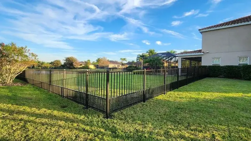 Residential fencing — home with black aluminum fence